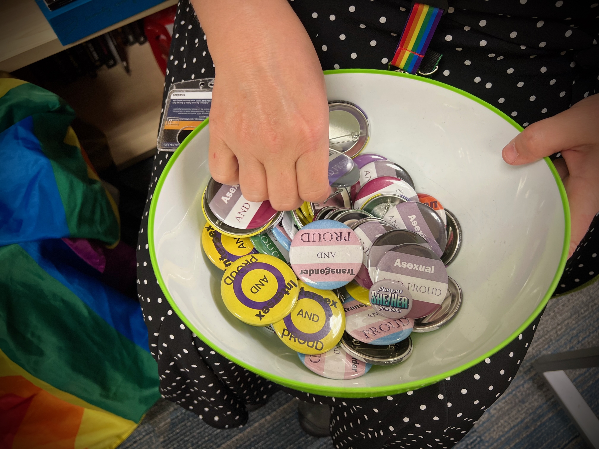 bowl with assortment and colors of lgbtqia affirming buttons